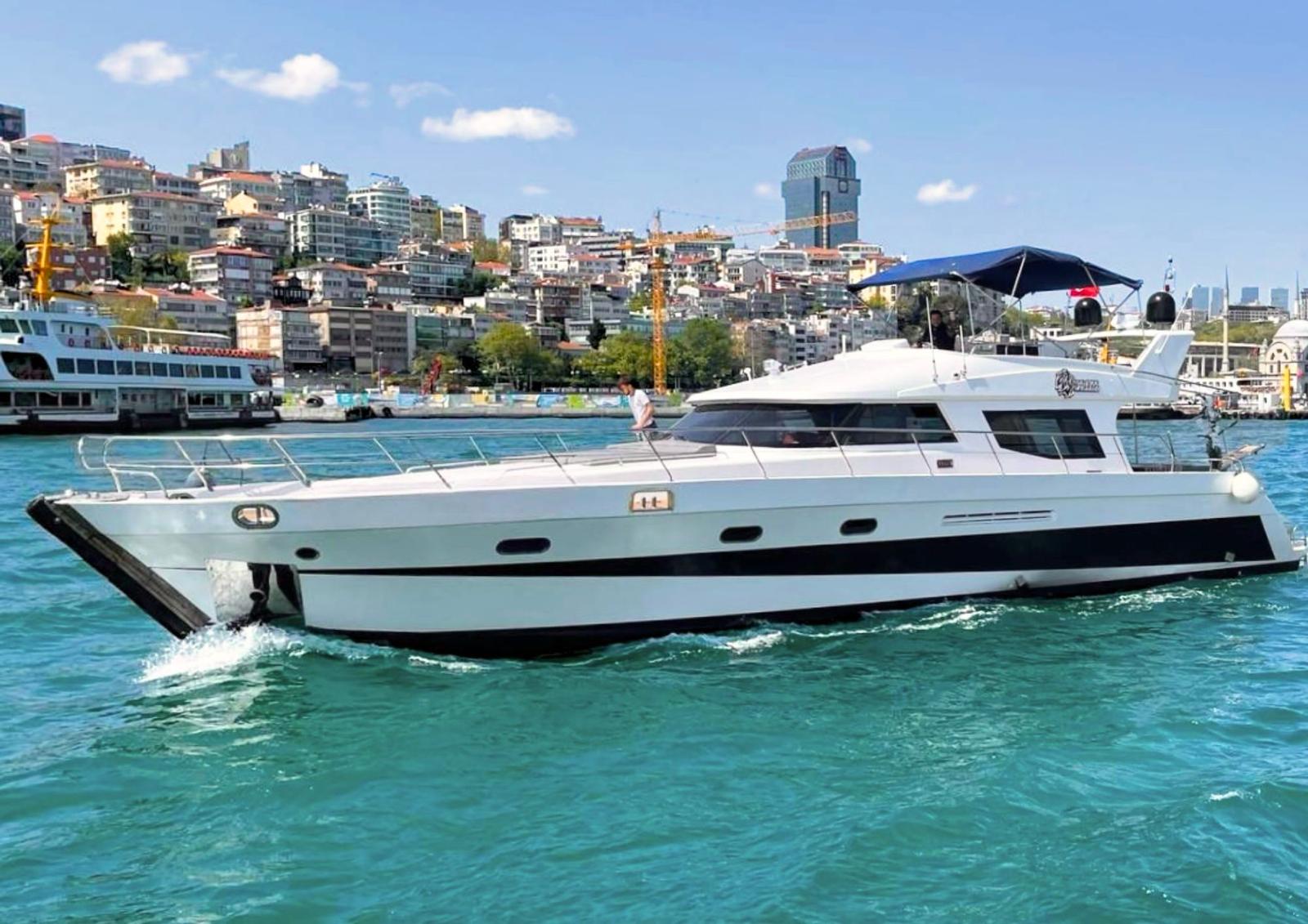 Private Brit & Berat yacht cruising on the Bosphorus with Istanbul skyline behind